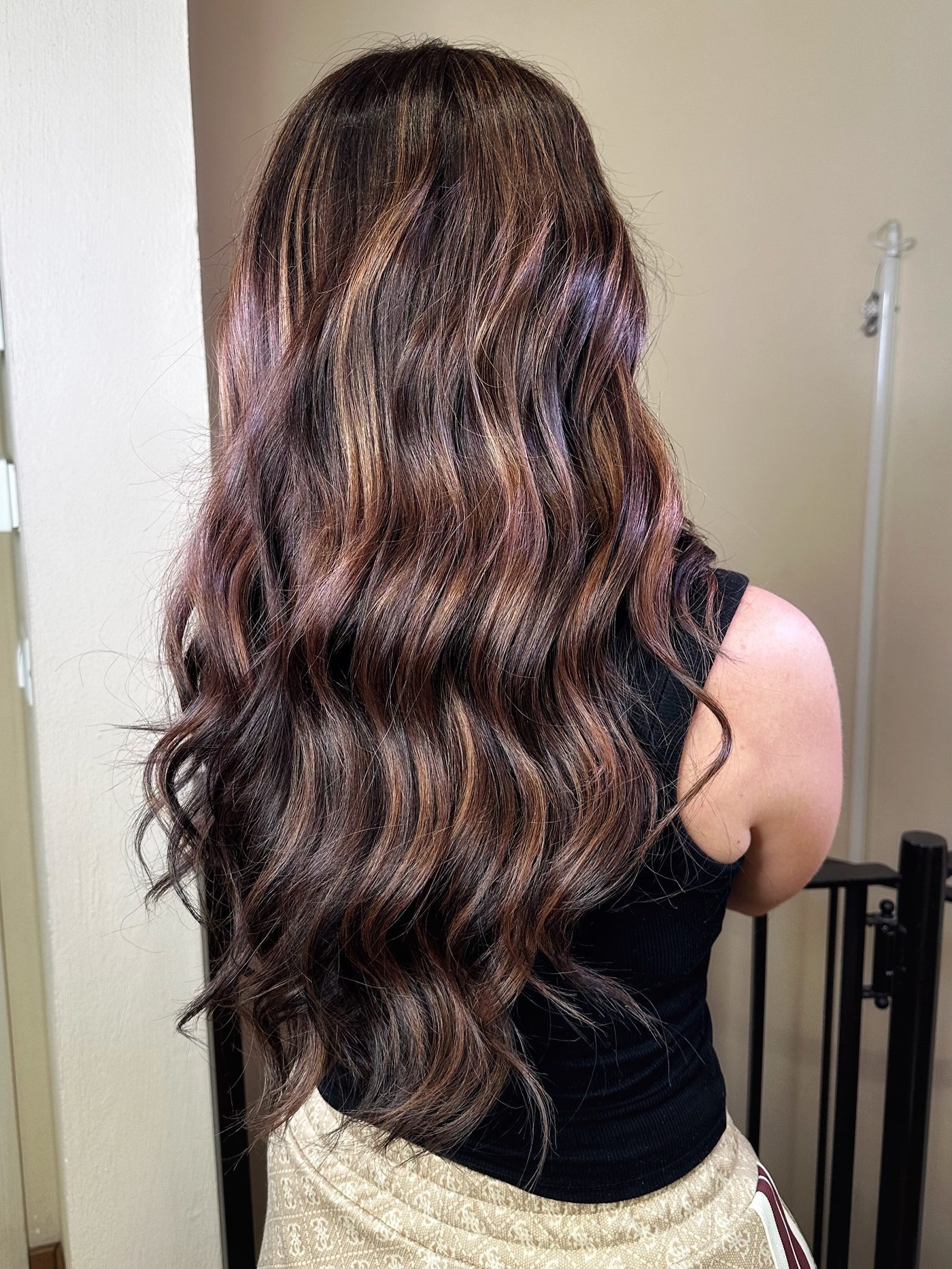 Capelli lunghi mossi con riflessi caldi e lucidi dopo il servizio colore